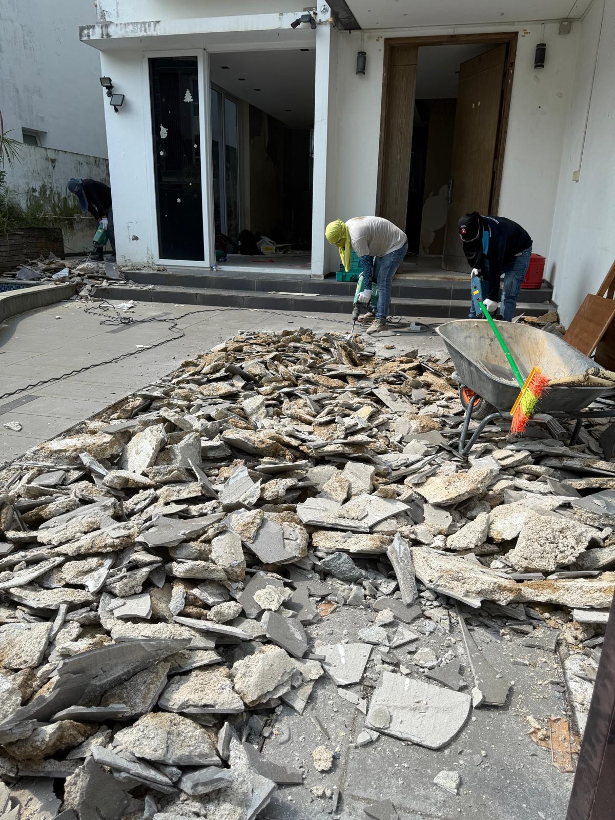 Landed house courtyard hack, crew clearing debris to the wheelbarrow